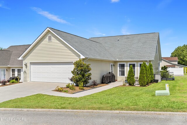 view of front of home with a front yard and a garage