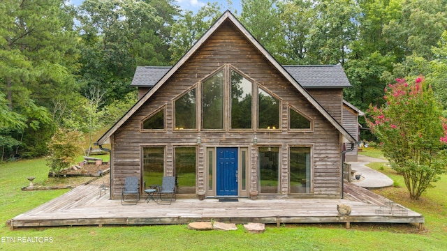 rear view of property featuring a lawn and a deck