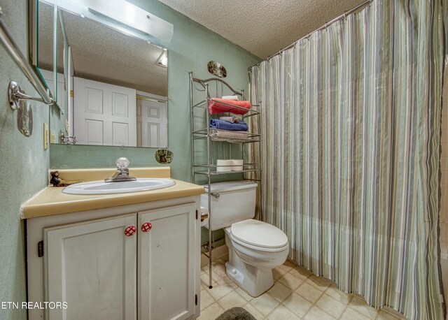 bathroom featuring tile patterned floors, a textured ceiling, vanity, and toilet