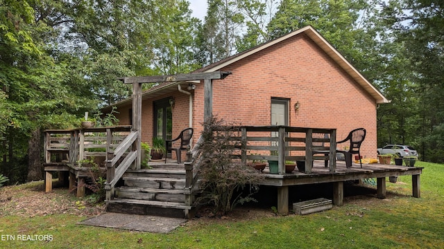 back of house with a wooden deck and a lawn