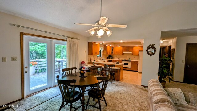 dining area with ceiling fan and light colored carpet