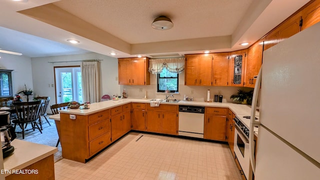 kitchen featuring light tile patterned floors, a wealth of natural light, kitchen peninsula, and white appliances