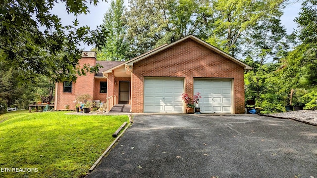 ranch-style house with a chimney, brick siding, aphalt driveway, a front lawn, and a garage