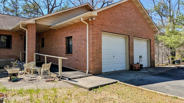 view of property exterior with brick siding and a garage