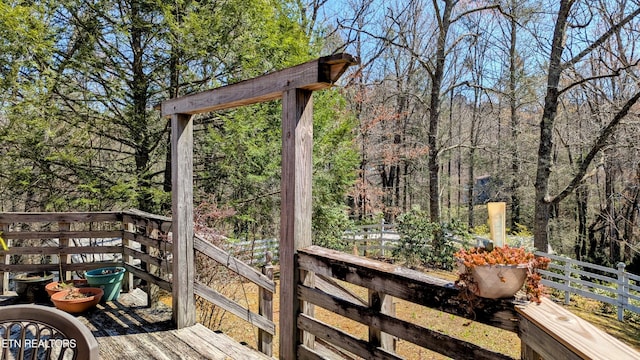 wooden terrace featuring a view of trees