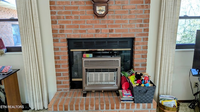 interior details featuring heating unit and a fireplace