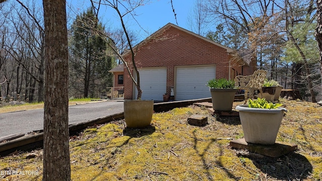 exterior space with brick siding and a garage