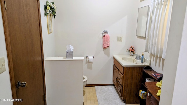 bathroom with baseboards, toilet, vanity, and tile patterned floors
