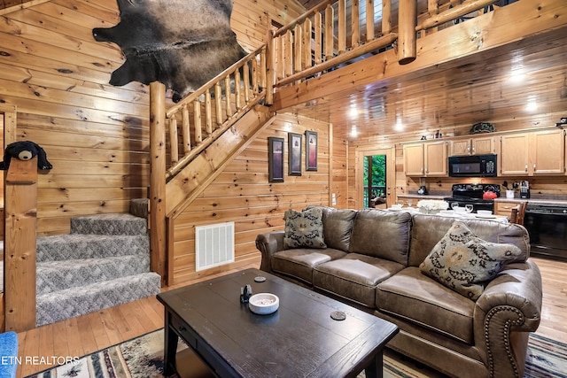 living room with light wood-type flooring and wood walls