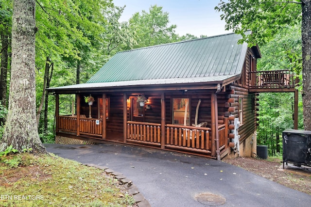 cabin featuring a porch and cooling unit