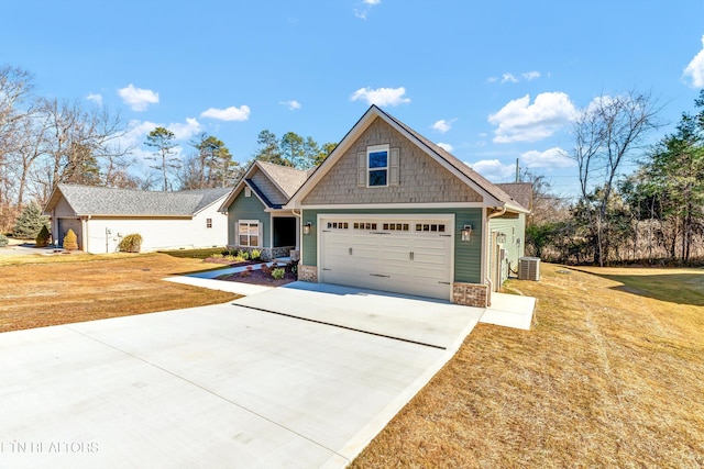 craftsman house with a garage, central AC unit, and a front yard