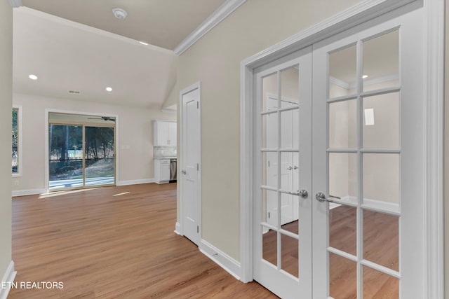 corridor featuring ornamental molding, light hardwood / wood-style floors, and french doors