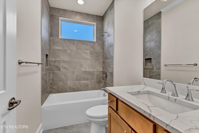 full bathroom featuring vanity, tiled shower / bath combo, and toilet