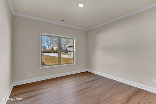 spare room featuring crown molding and light wood-type flooring