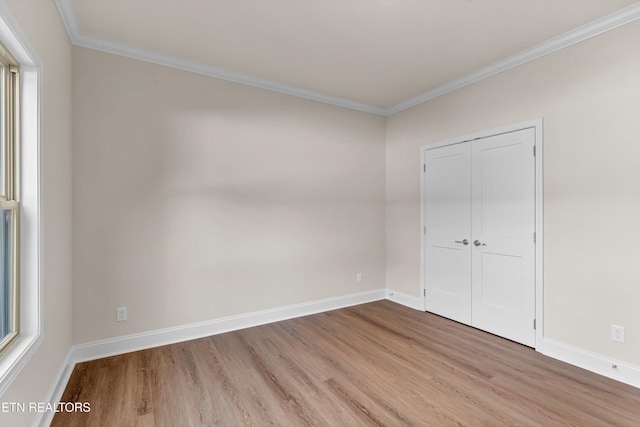 unfurnished bedroom featuring ornamental molding, light hardwood / wood-style floors, and a closet