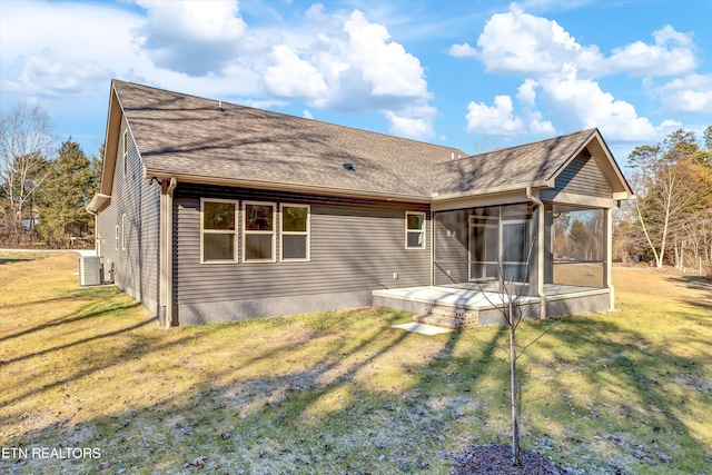 back of house featuring central AC, a lawn, and a sunroom