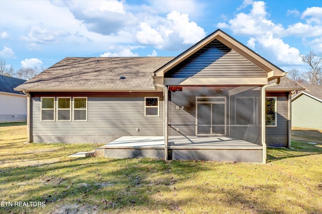 rear view of property with a sunroom and a lawn