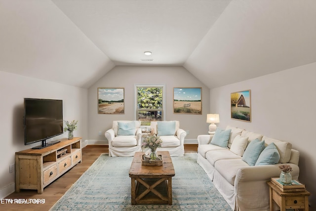 living room featuring vaulted ceiling, wood finished floors, and baseboards
