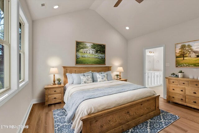 bedroom featuring light wood-type flooring, ceiling fan, connected bathroom, and vaulted ceiling