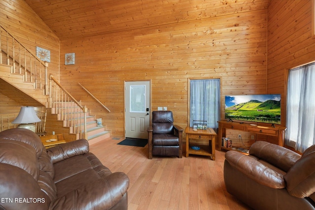 living room featuring wood walls, high vaulted ceiling, wood ceiling, and light hardwood / wood-style flooring