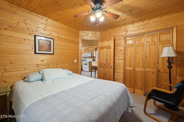 bedroom with wooden ceiling, ceiling fan, and wood walls