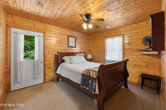 carpeted bedroom with wood walls, ceiling fan, and wooden ceiling