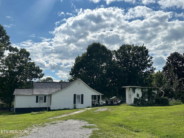 view of home's exterior with driveway and a lawn