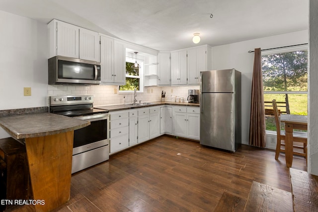 kitchen featuring appliances with stainless steel finishes, decorative backsplash, white cabinetry, sink, and dark hardwood / wood-style flooring