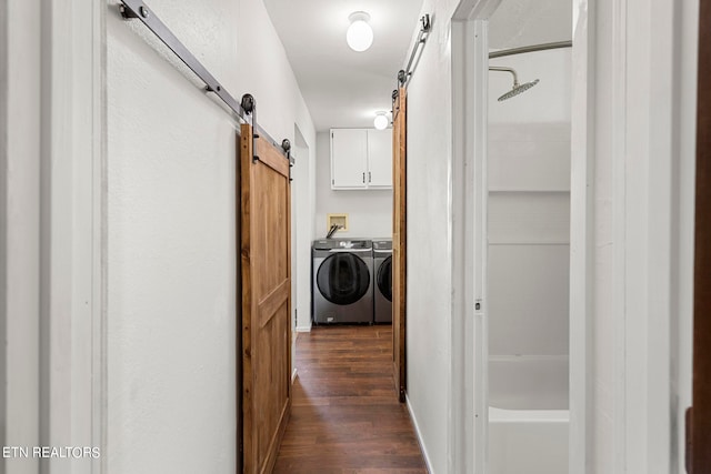 hallway with independent washer and dryer, dark wood-type flooring, and a barn door