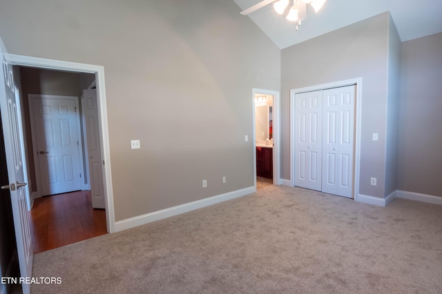 unfurnished bedroom with carpet floors, high vaulted ceiling, ceiling fan, and a closet