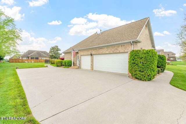 view of property exterior with a garage and a yard