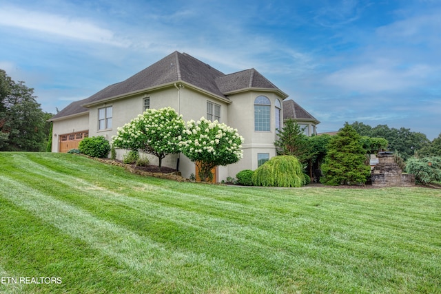 view of property exterior featuring a garage and a yard