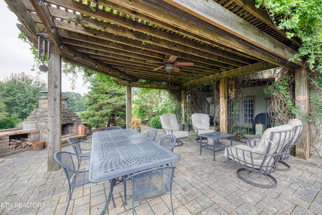 view of patio featuring ceiling fan and an outdoor stone fireplace