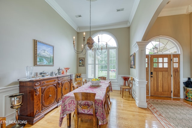 dining area featuring an inviting chandelier, light hardwood / wood-style flooring, and ornamental molding