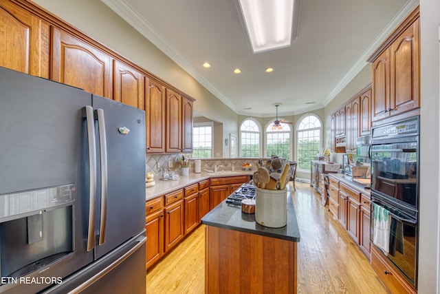 kitchen featuring stainless steel appliances, crown molding, decorative backsplash, and a center island