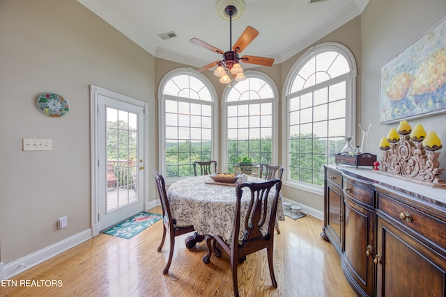 dining space featuring ornamental molding, light hardwood / wood-style flooring, and a healthy amount of sunlight