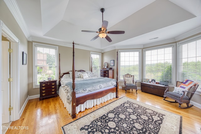 bedroom featuring ceiling fan, ornamental molding, a raised ceiling, and hardwood / wood-style floors