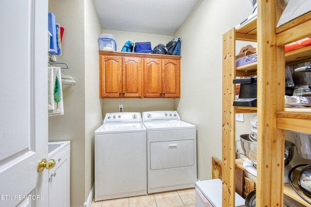 laundry area with cabinets, light tile patterned floors, and washer and clothes dryer