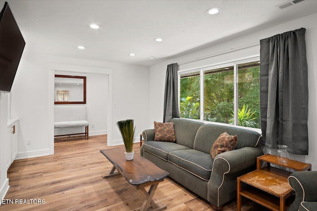 living room with light wood finished floors, visible vents, recessed lighting, and baseboards