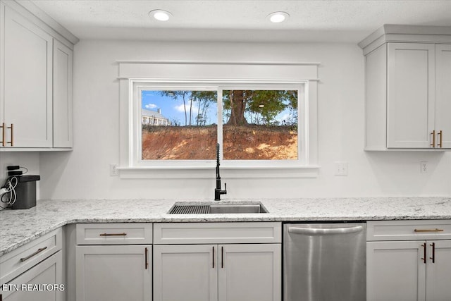 kitchen featuring light stone countertops, recessed lighting, a sink, a textured ceiling, and dishwasher