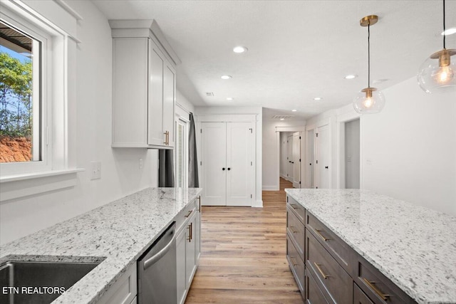 kitchen with light stone counters, recessed lighting, pendant lighting, dishwasher, and light wood-type flooring