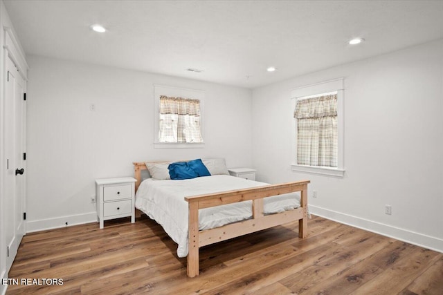 bedroom with recessed lighting, baseboards, and wood finished floors