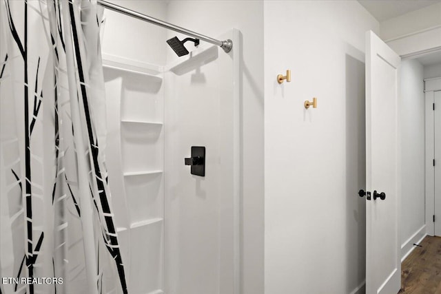 bathroom featuring curtained shower and wood finished floors