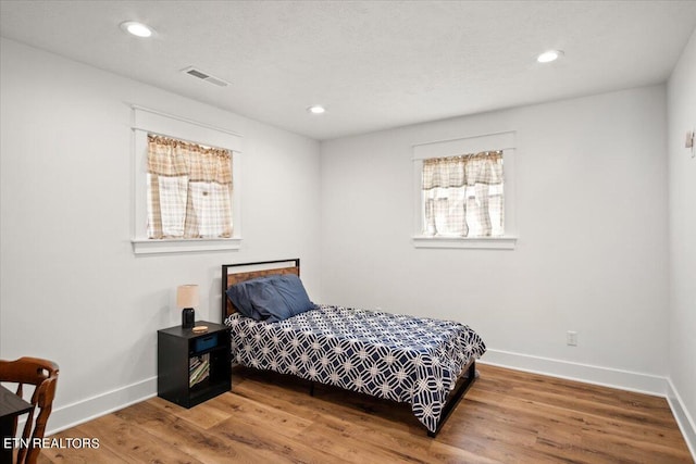 bedroom featuring visible vents, recessed lighting, baseboards, and wood finished floors