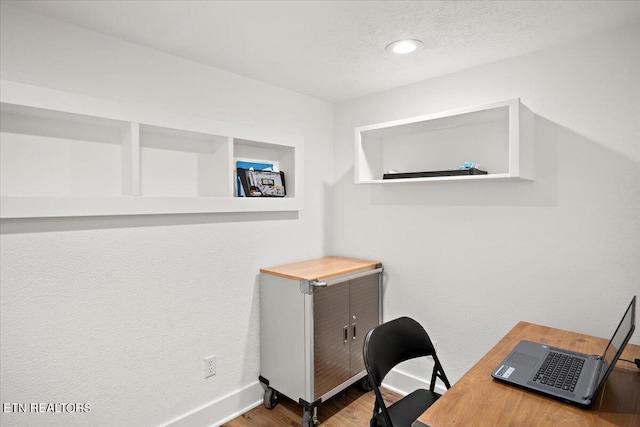 office space with wood finished floors, baseboards, and a textured ceiling