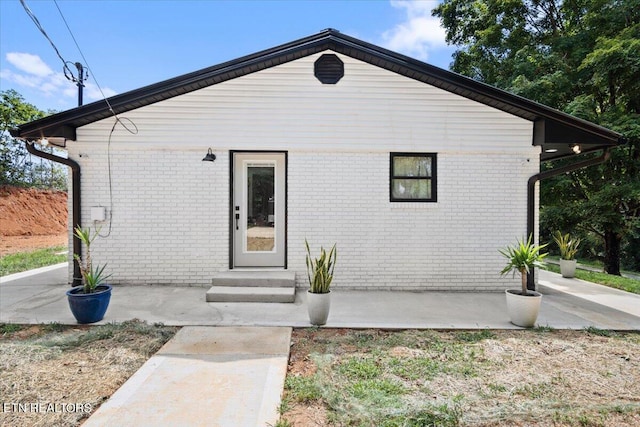 view of front facade with brick siding and entry steps