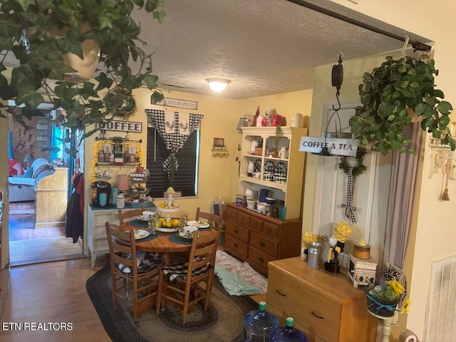 dining room featuring a textured ceiling and hardwood / wood-style floors