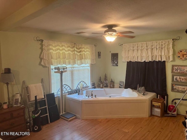 bathroom featuring ceiling fan, a bathtub, and wood-type flooring