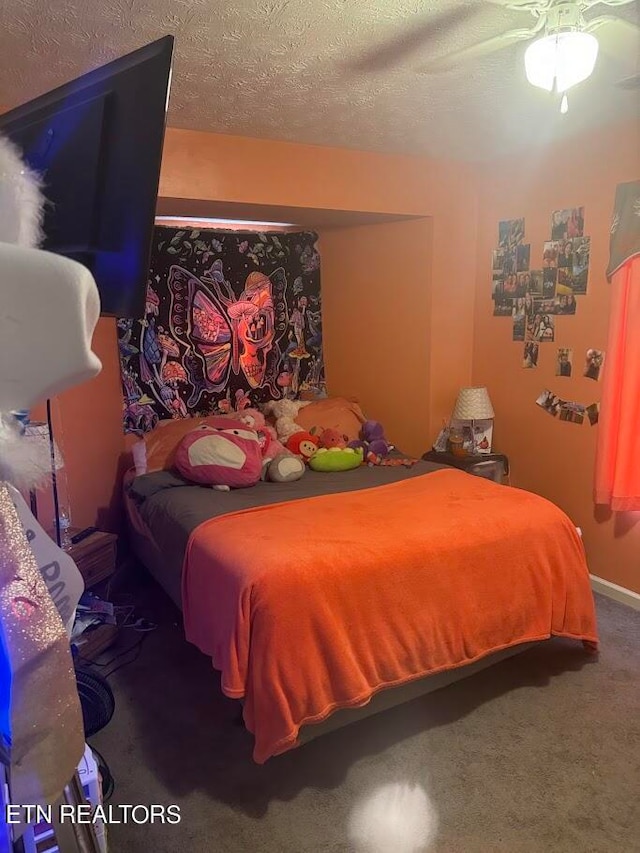 bedroom featuring ceiling fan, a textured ceiling, and carpet flooring