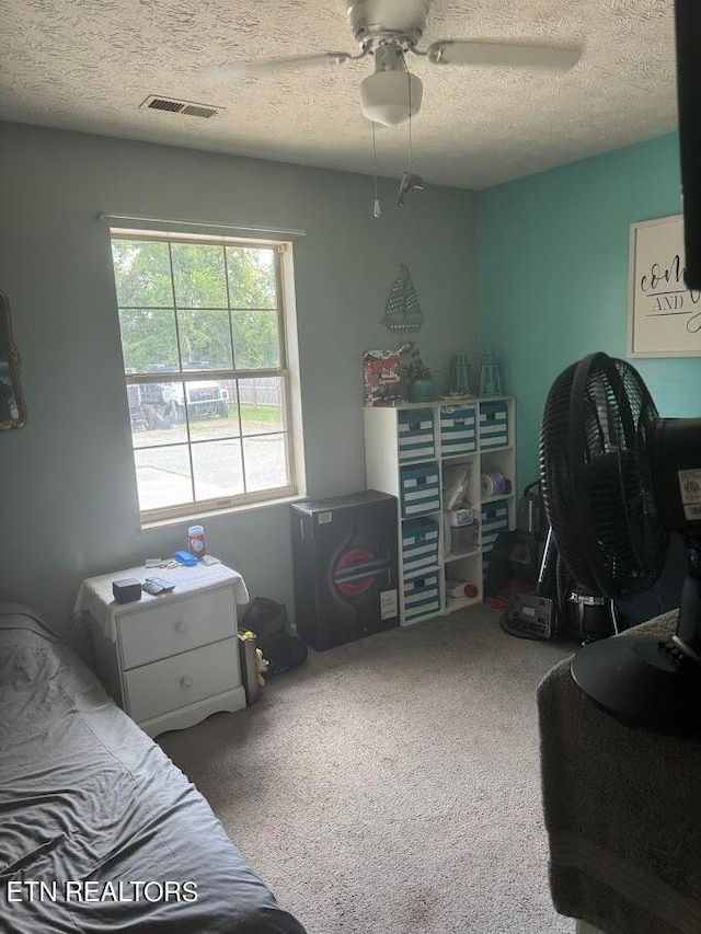 bedroom featuring a textured ceiling, carpet floors, and ceiling fan